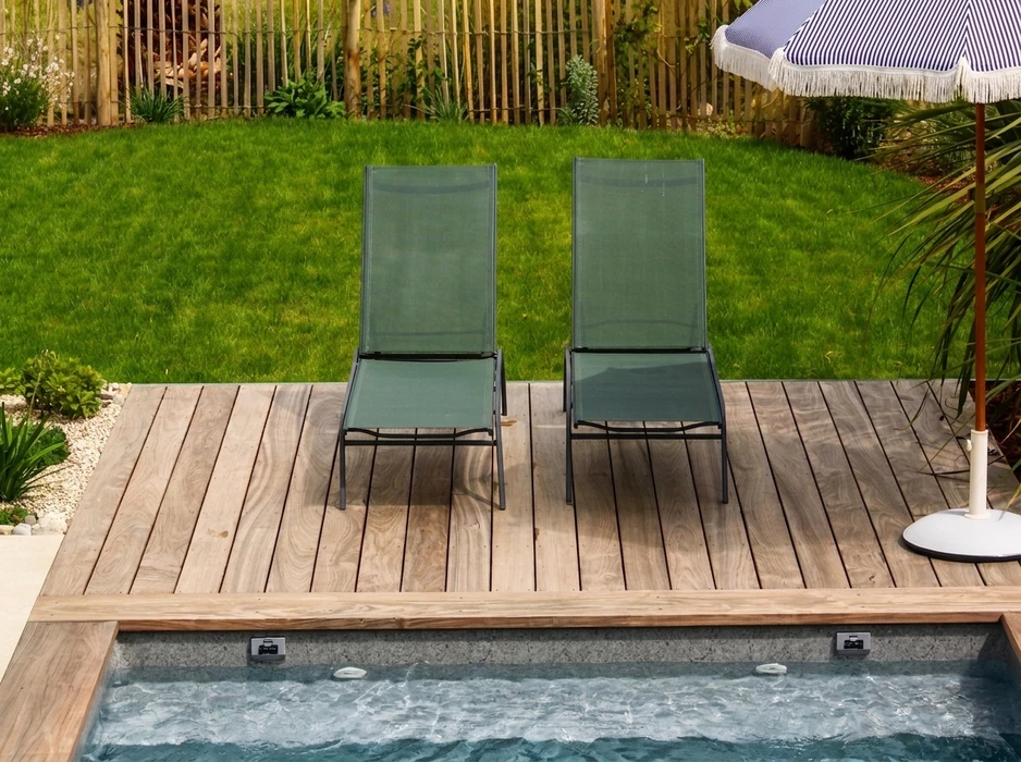 Terrasse en bois exotique type teck posée en lames parallèles autour d'une piscine enterrée