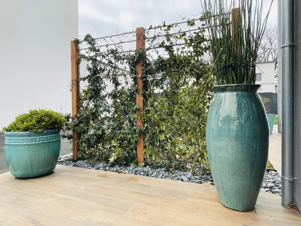 Terrasse extérieure contemporaine avec deux grands pots en céramique émaillée turquoise
