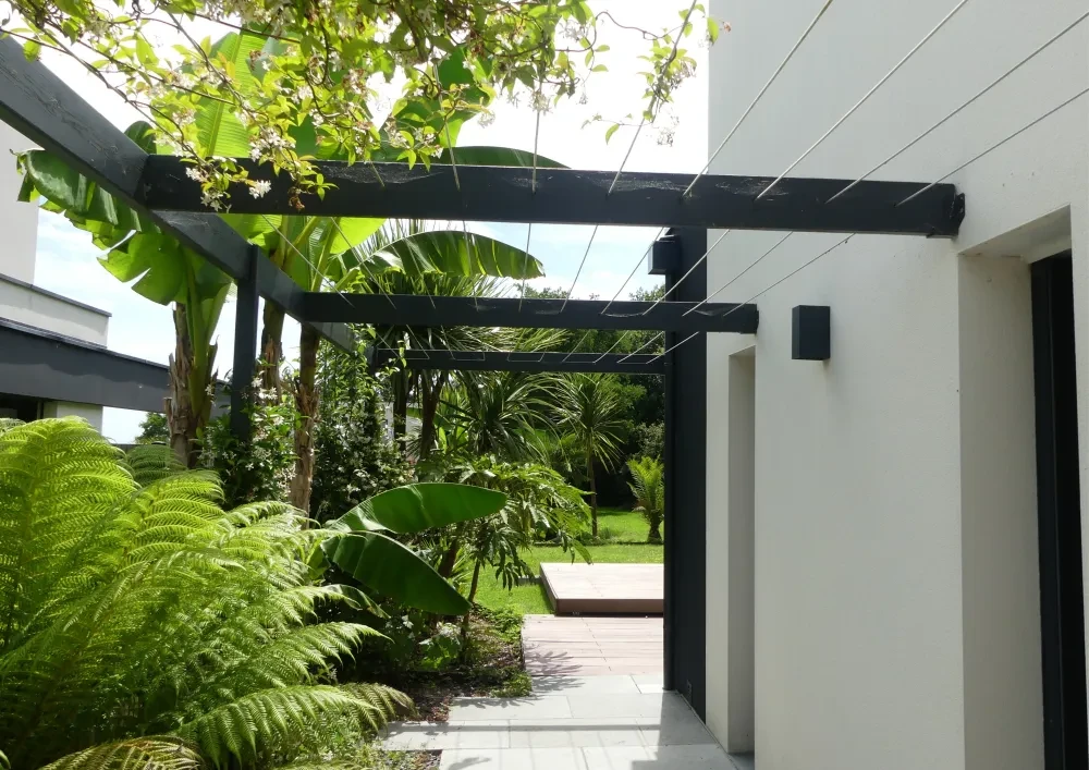 Clôture de jardin extérieure composée de cannes de bambou naturel et de lames de béton fibré gris ardoise, alternées verticalement
