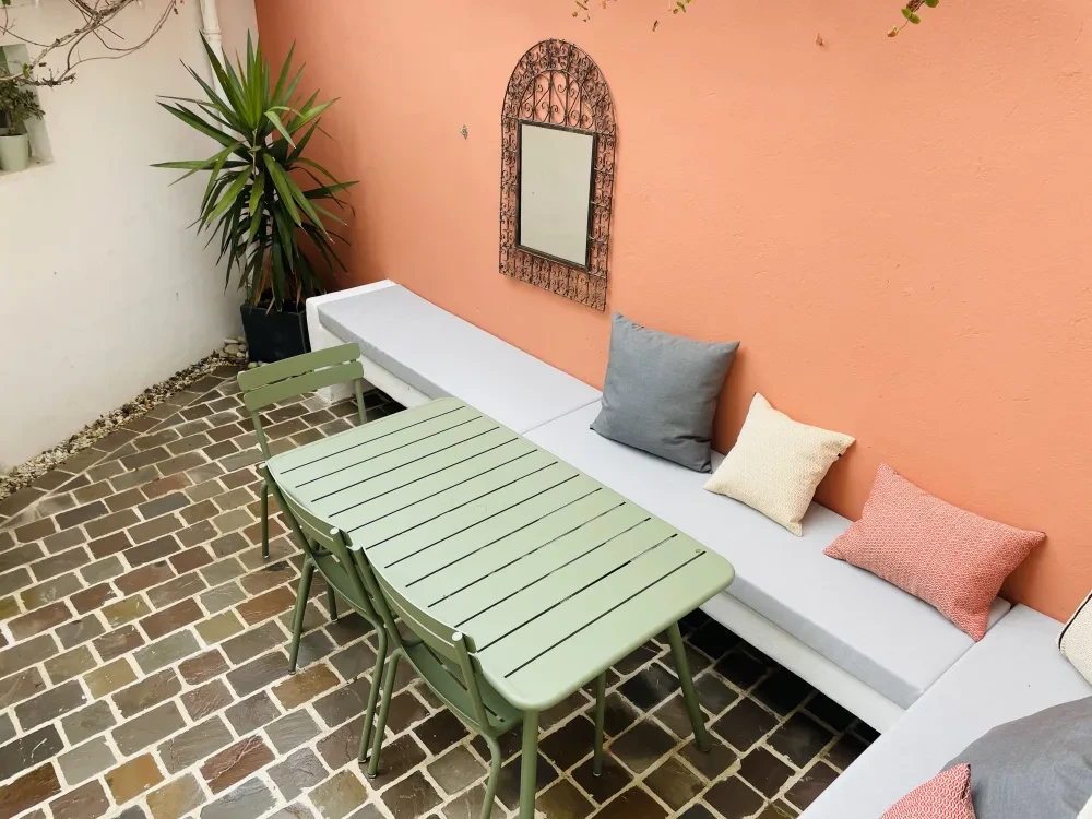 Terrasse de restaurant en bois avec pergola en charpente bois apparente, balustrade métallique noire avec panneaux en verre