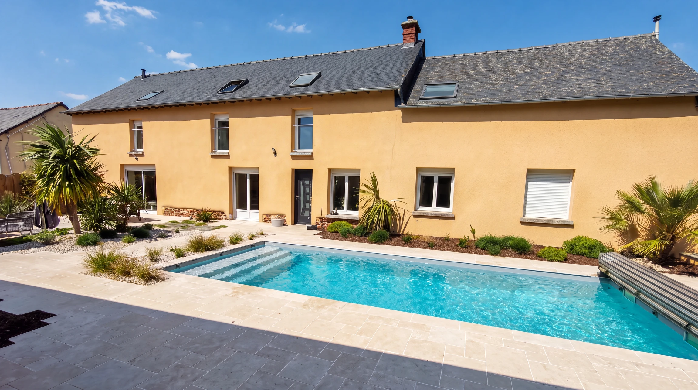 Terrasse extérieure moderne d'une maison contemporaine, combinant dalles de béton clair et lames de bois composite en ipé